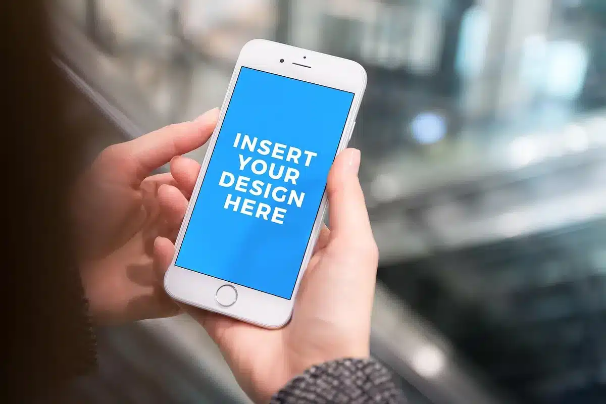 Anonymous hands holding an unbranded smartphone displaying a bright AMOLED wallpaper, background blurred